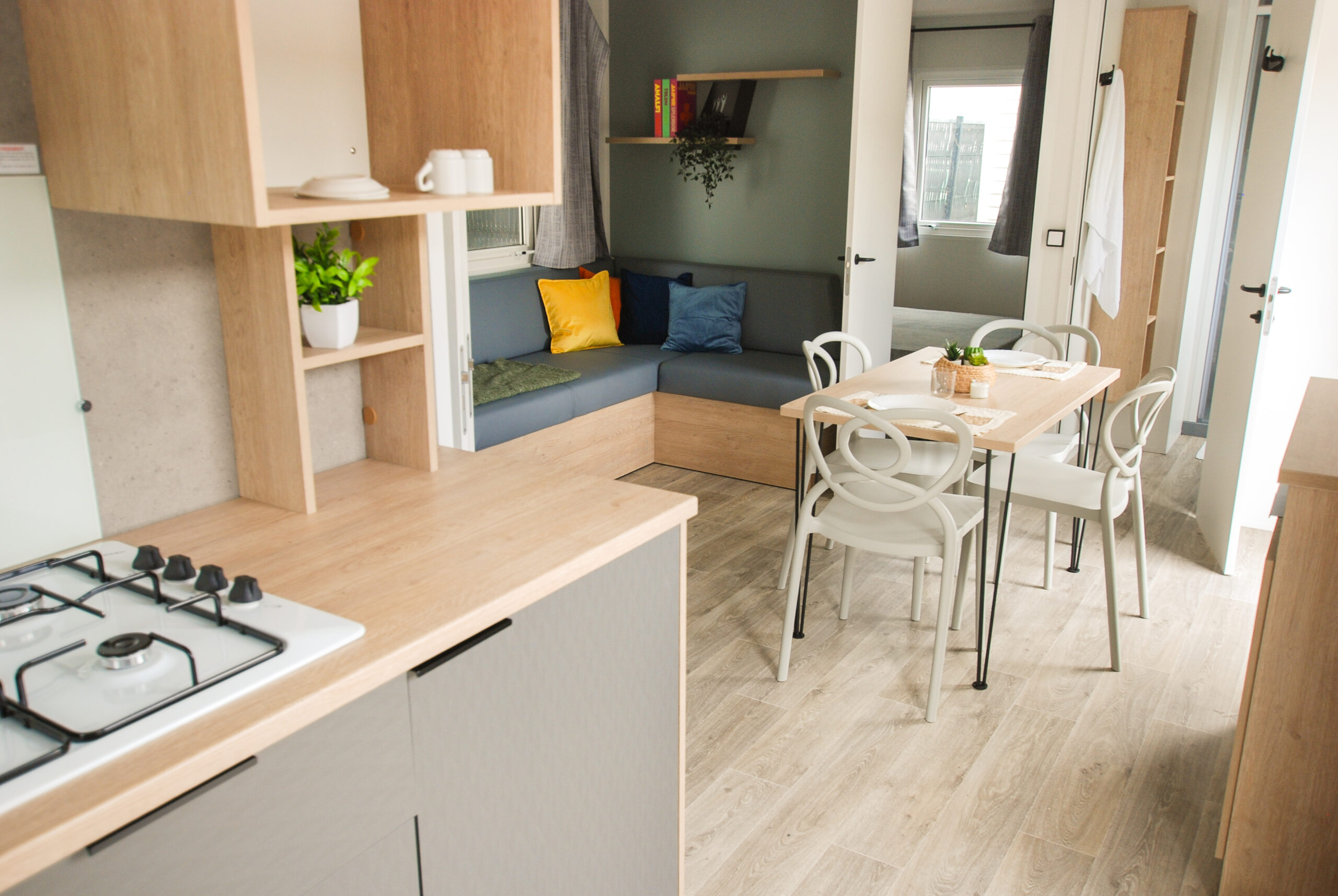 Intérieur d'un mobil home à vendre dans les Landes, avec cuisine ouverte, table à manger et canapé dans une pièce lumineuse
