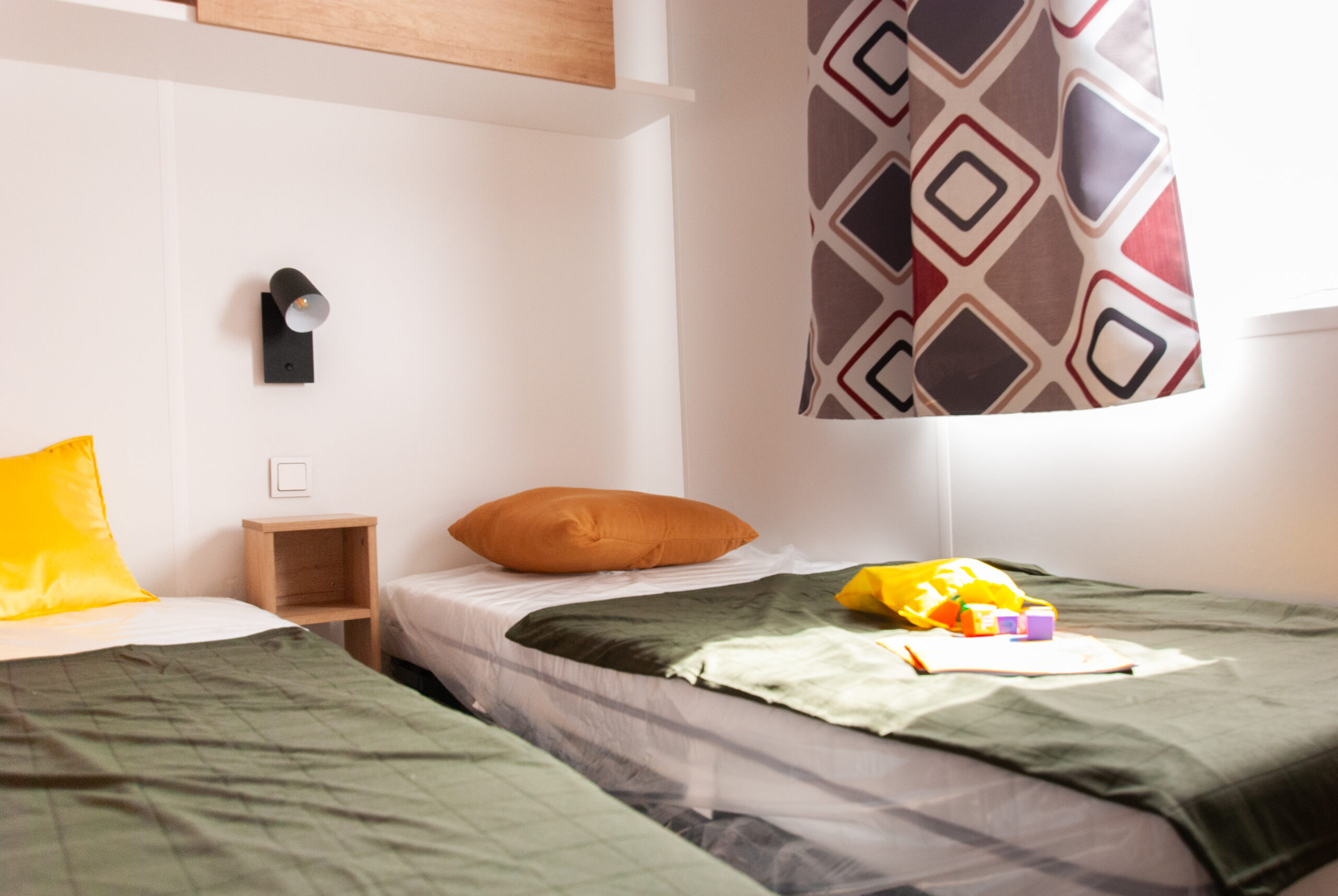 Luminosa habitación de invitados en el mobil-home Rapid'home Elite 902 en venta en las Landas, ideal para los niños con una iluminación natural y una decoración acogedora.