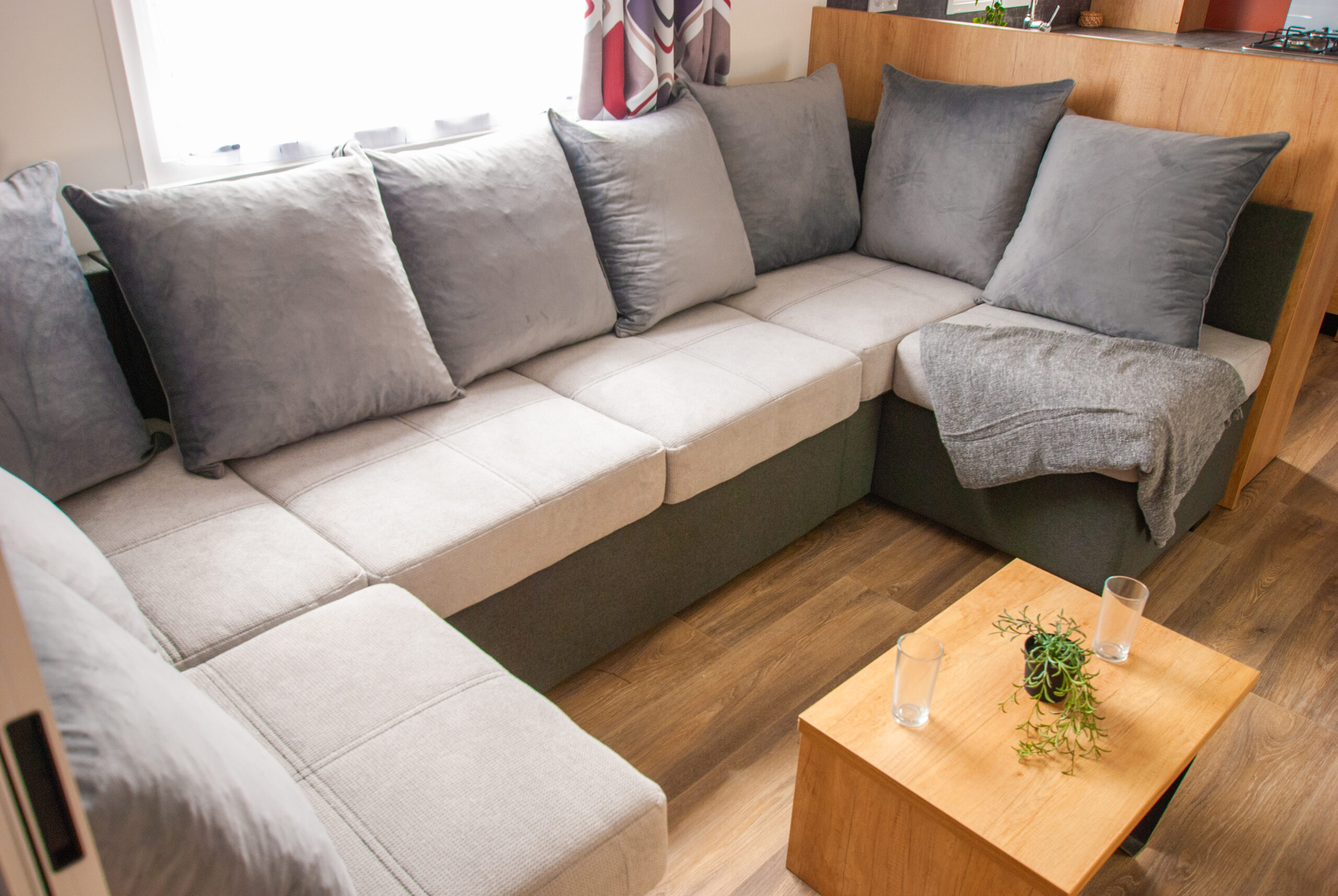 Intérieur du mobil-home Rapid'home Élite 1040 avec grand canapé tout confort, 2 salles de bains et 3 chambres, à vendre dans les Landes.