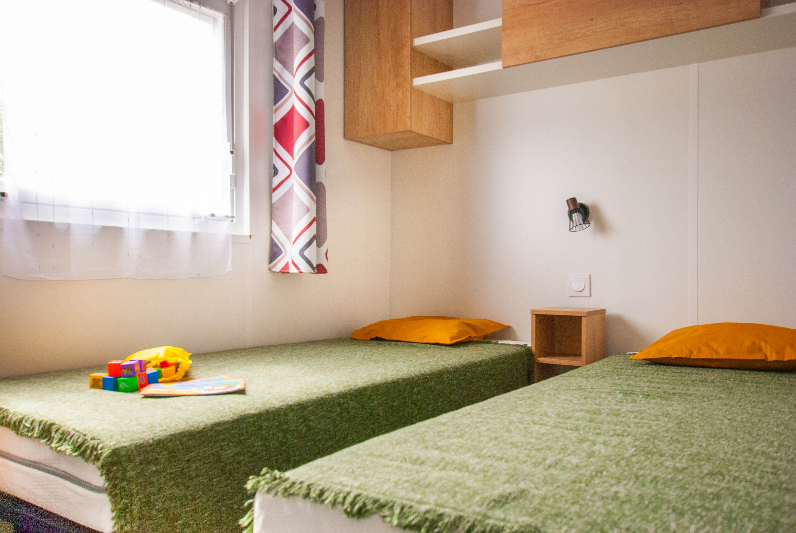 Intérieur mobil home Rapid'home Élite 1040 - Seconde chambre lumineuse avec lits simples, idéal pour famille, fonctionnelle et bien agencée, à vendre dans les Landes.