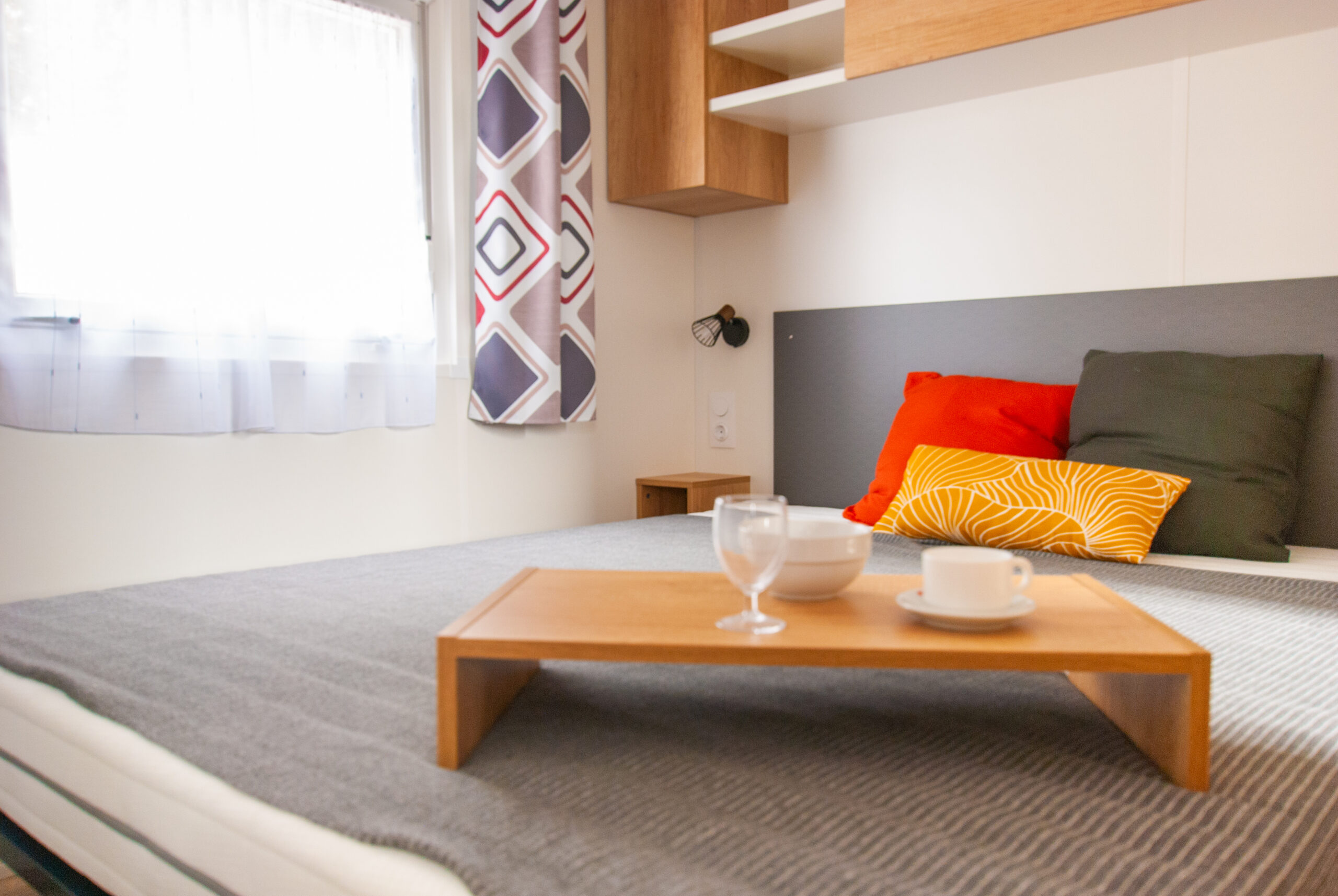 Intérieur mobil-home Rapid'home élite 1040 avec lit double dans la chambre suite parentale lumineuse, fenêtre spacieuse, 2 salles de bains et 3 chambres, à vendre dans les Landes.