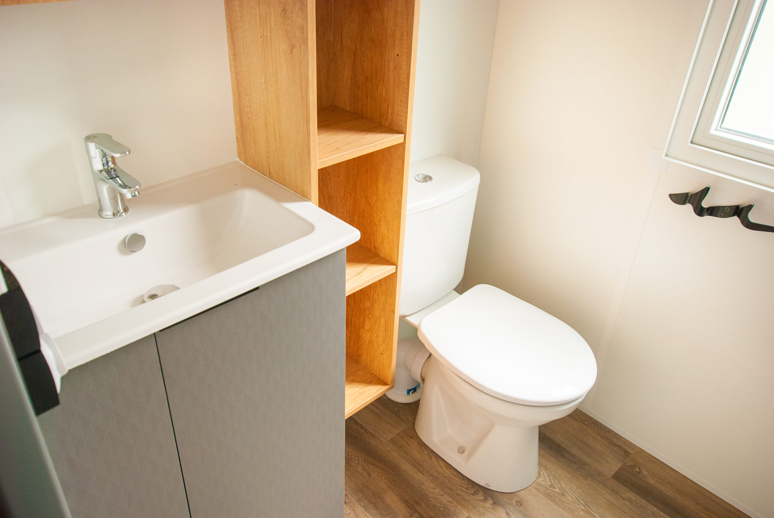 Intérieur du mobil home Rapid'home élite 1040 avec vue sur les WC et la salle de bains de la suite parentale, offrant confort et commodité pour des vacances en famille dans les Landes, idéal pour 3 chambres et 2 salles de bains.