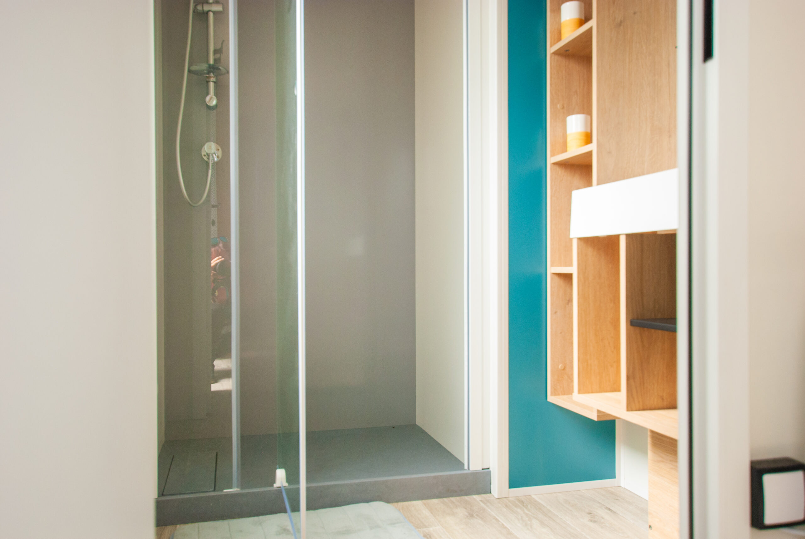 Intérieur du mobil home Rapid'home Lodge 83 : salle de bain spacieuse avec douche moderne, lavabo élégant et nombreux rangements pour un confort optimal, à vendre dans les Landes