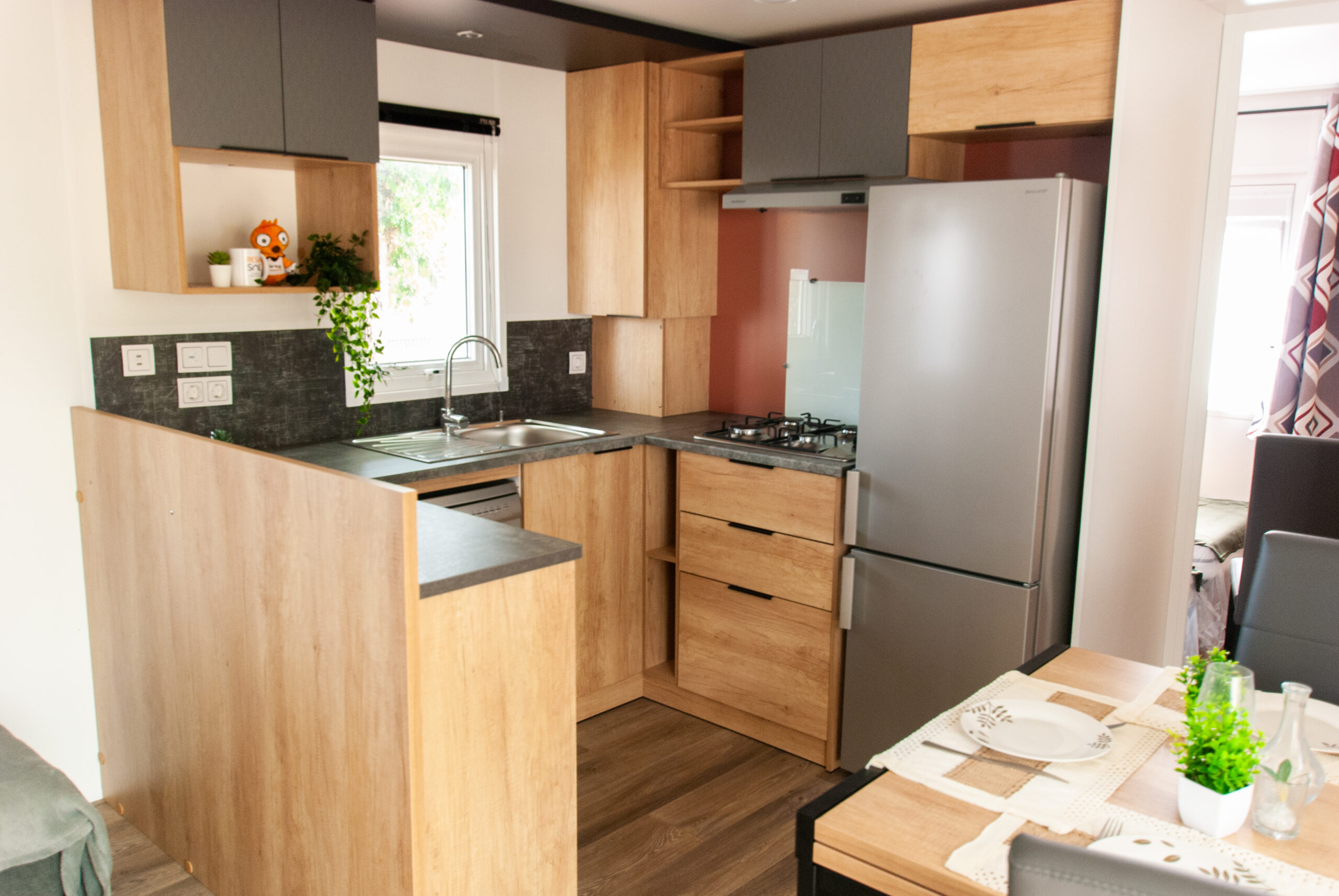 Interior de la cocina de la casa móvil Rapid'home Elite 902 en venta en las Landas, con amplia superficie de trabajo y electrodomésticos nuevos, que ofrecen un agradable ambiente de vida.