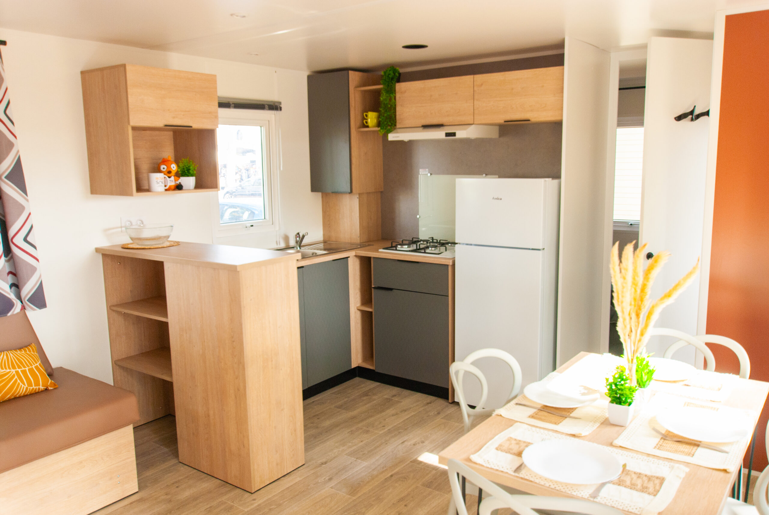 Intérieur moderne du mobil home Rapid'home LO872 à vendre dans les Landes, montrant l'entrée, salle à manger, salon et cuisine, idéal pour des vacances en famille.